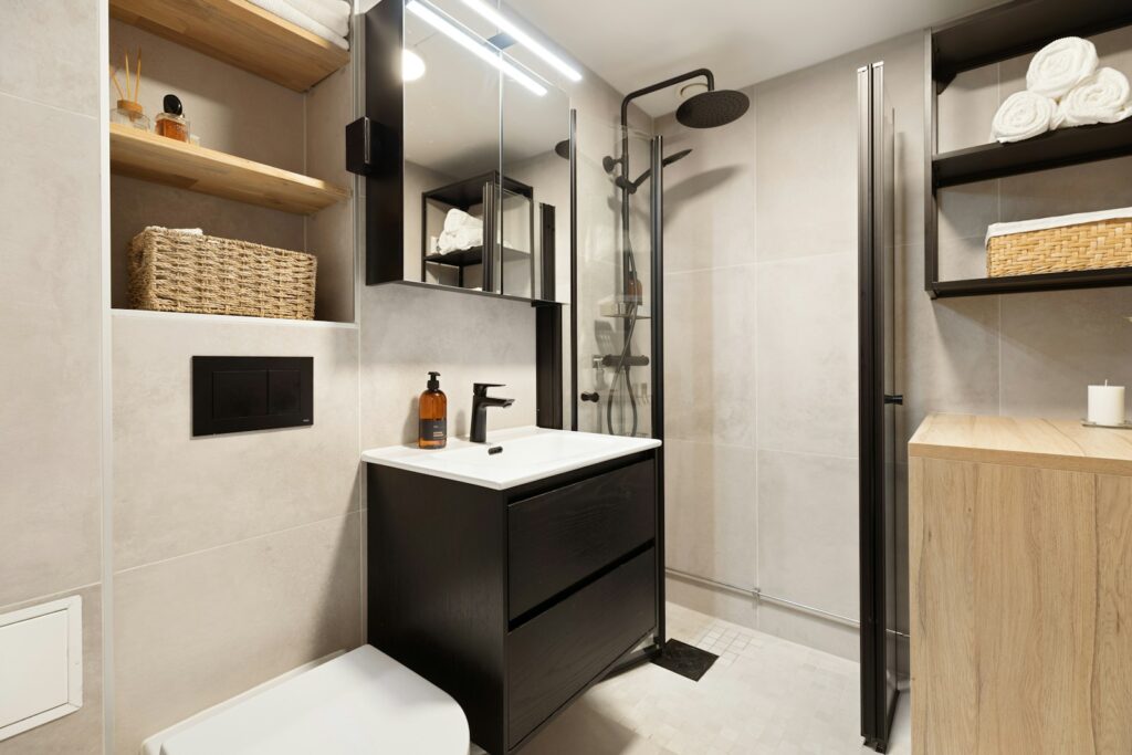 A bathroom with a toilet, sink, and shelves